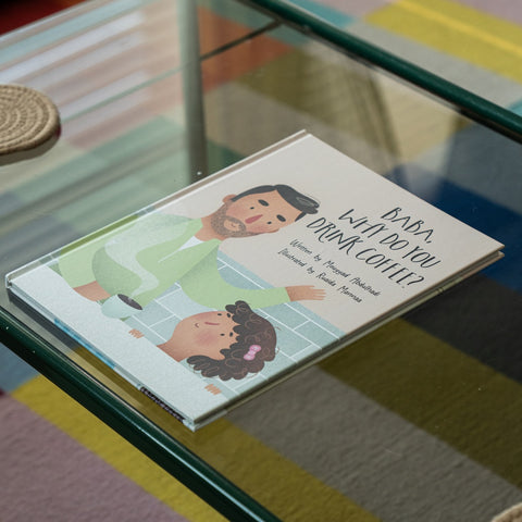 Hardcover children's book Baba, Why Do You Drink Coffee? illustrated with a father holding a coffee cup and a smiling child